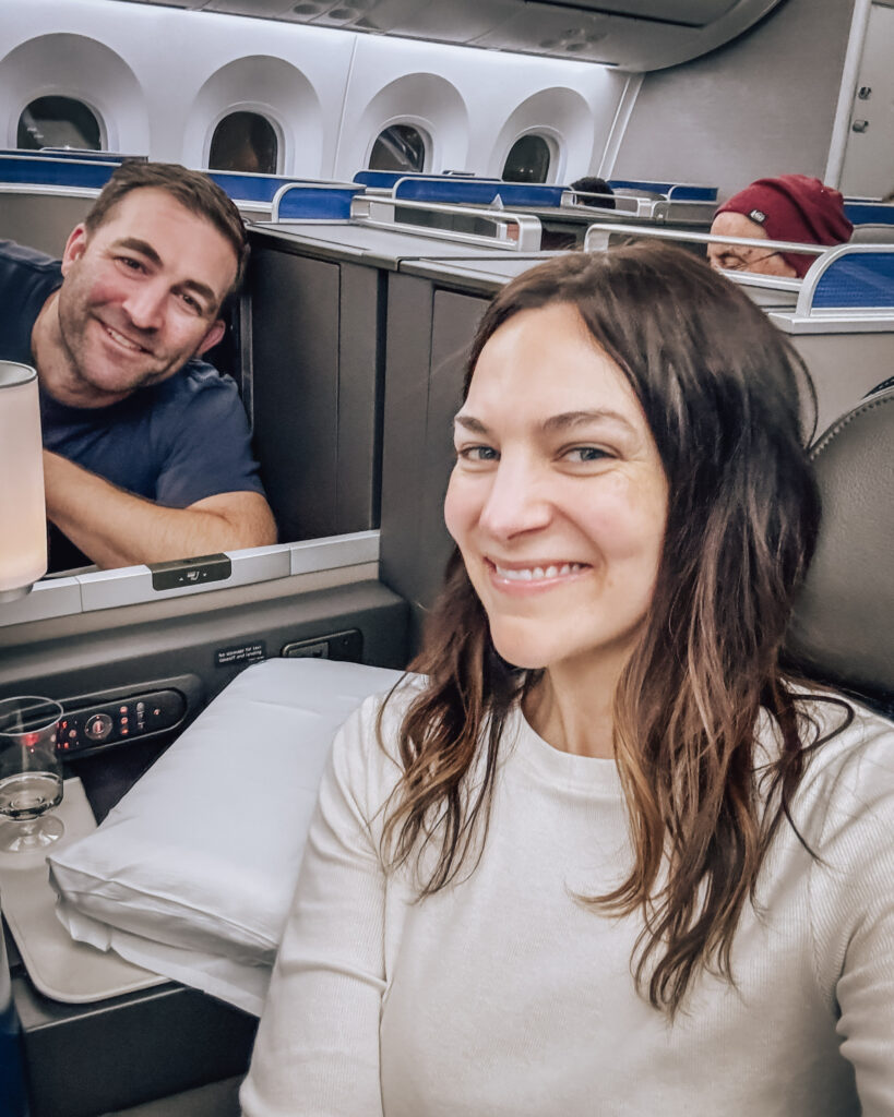 Couple flies for nearly free in first class with points and miles, enjoying the rest while their kids sit in front of them. Photo by Amy Berrian