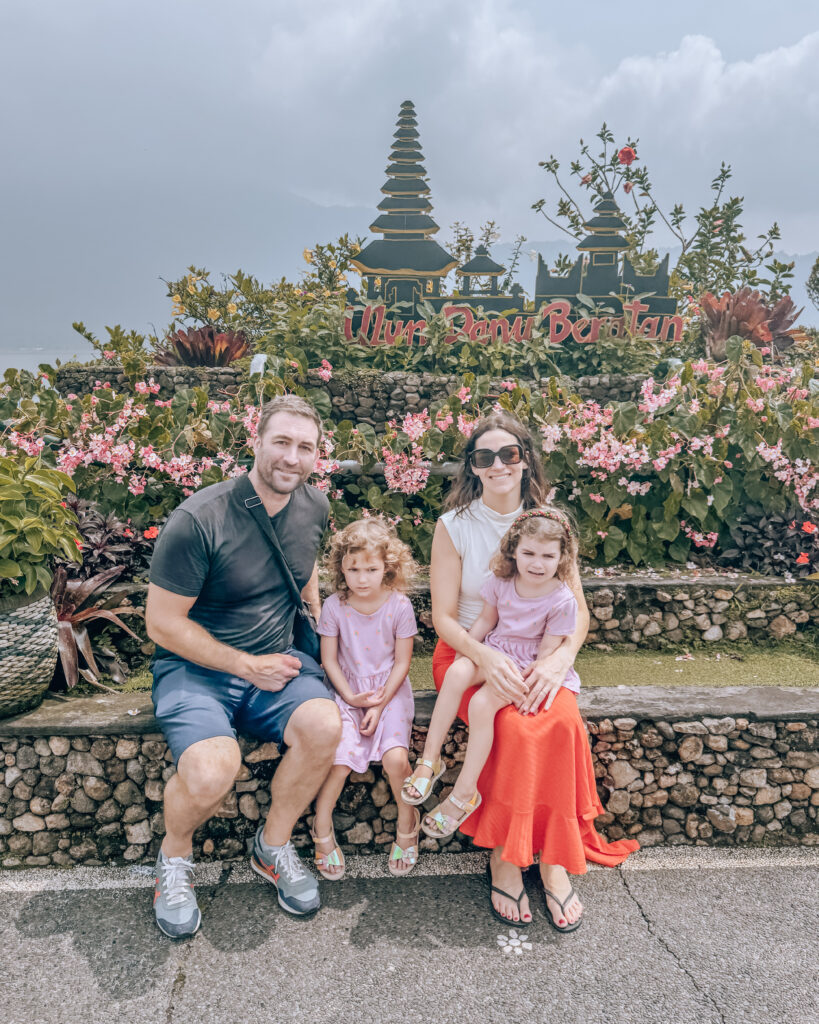 Family exploring the serene Ulun Danu Beratan Temple in Bali after flying first class nearly free with credit card rewards and enjoying a week of free hotel stays.