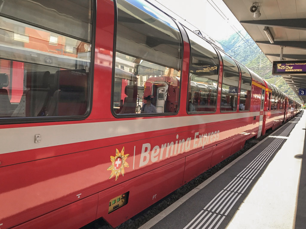 Parked at the train station sits the cherry red Bernina Express, one of the most scenic train rides in Switzerland.