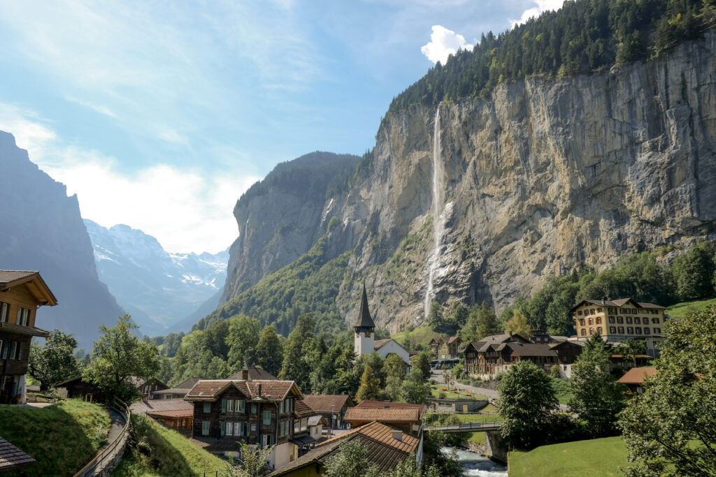 A waterfall tumbles off of the lush green mountain in Wengen, Switzerland. 