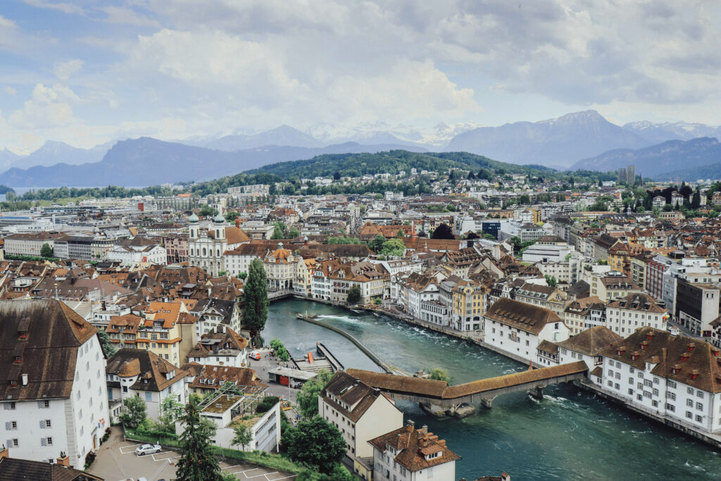 Elevated view of Lucerne, Switzerland in the summer. teal blue waters, lush green mountains and the quaint village below.