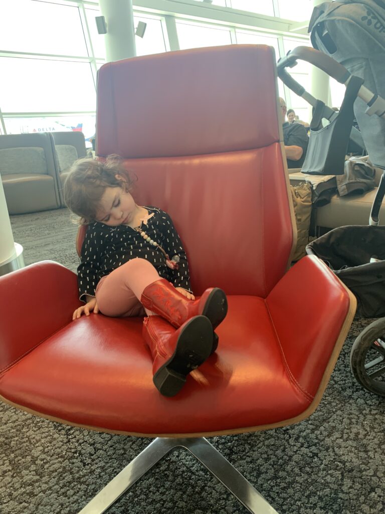 We were stuck at the airport for more than 24 hours because of cancellations, and now my baby is sleeping on a chair. The worst. Photo by Amy Berrian.